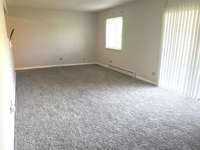 carpeted empty room featuring a baseboard radiator and baseboards