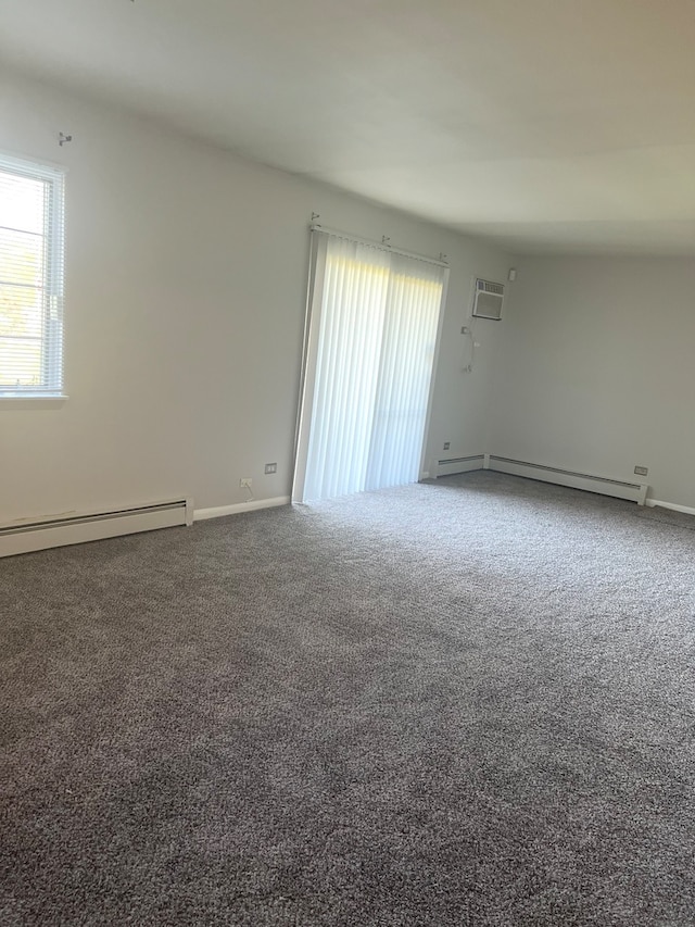 unfurnished room featuring a baseboard heating unit, a wall unit AC, and carpet