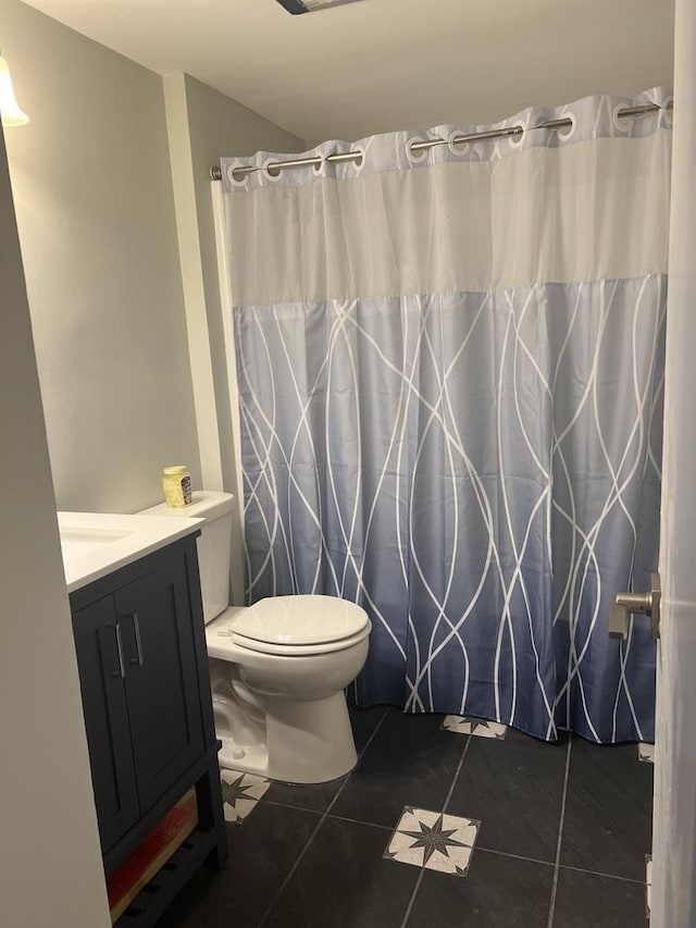 full bathroom with tile patterned floors, curtained shower, toilet, and vanity