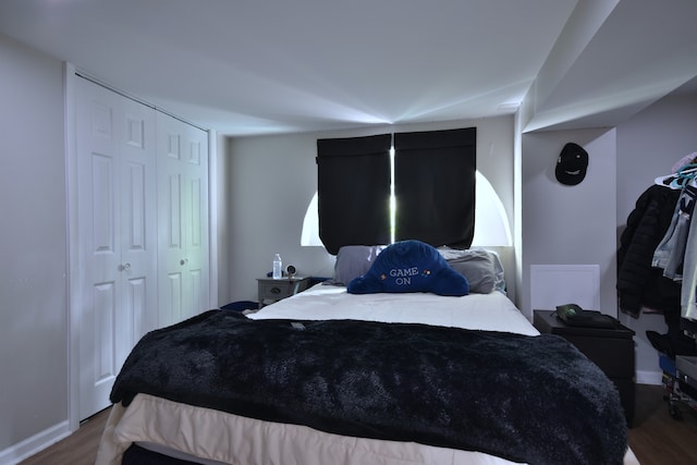 bedroom with a closet and dark hardwood / wood-style flooring