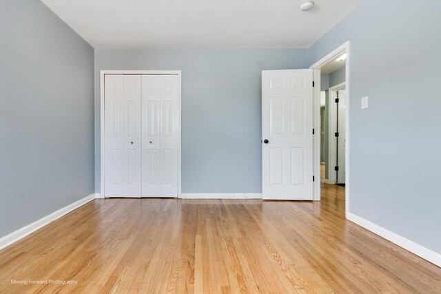 unfurnished bedroom featuring a closet and light wood-type flooring