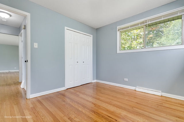 unfurnished bedroom featuring light wood-type flooring and a closet