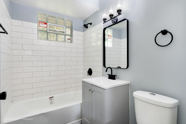 full bathroom with tiled shower / bath, toilet, and vanity