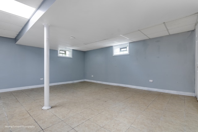 basement featuring a healthy amount of sunlight, light tile patterned floors, and a drop ceiling