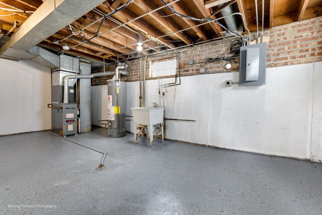 basement with heating unit, water heater, electric panel, and sink