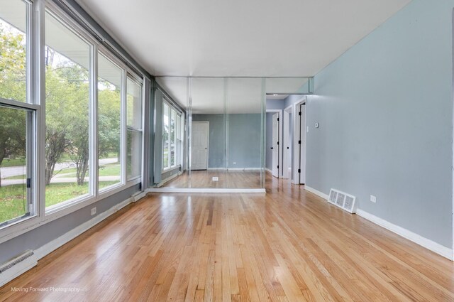 unfurnished room with light hardwood / wood-style flooring and a baseboard radiator