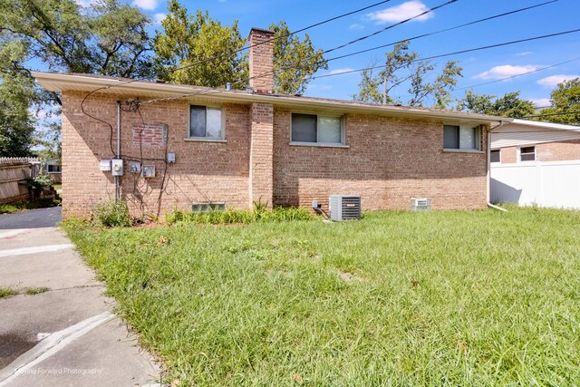 view of property exterior with cooling unit and a yard