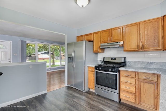 kitchen with appliances with stainless steel finishes, dark wood-type flooring, and decorative backsplash