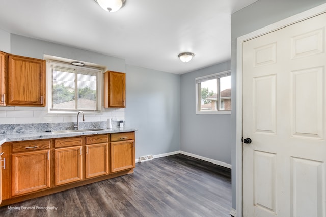 kitchen with dark wood-type flooring, plenty of natural light, backsplash, and sink