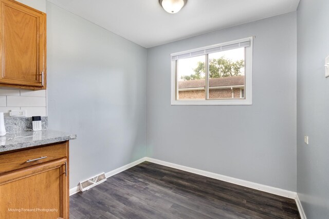 unfurnished dining area featuring dark hardwood / wood-style floors