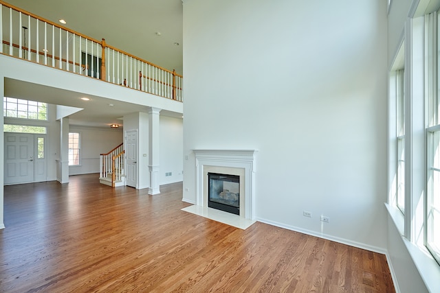 unfurnished living room featuring a high ceiling and hardwood / wood-style floors