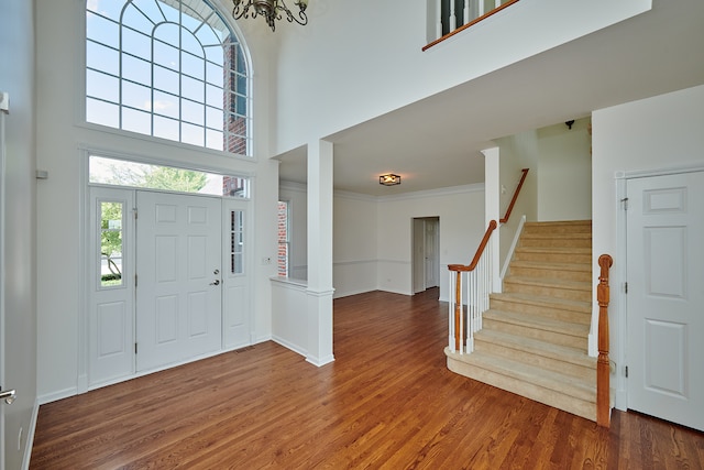 foyer featuring a high ceiling, ornamental molding, and hardwood / wood-style flooring