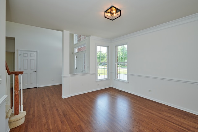 empty room featuring ornamental molding and dark hardwood / wood-style floors