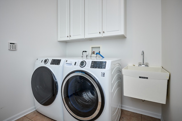 laundry room featuring cabinets, washer and clothes dryer, sink, and light tile patterned floors