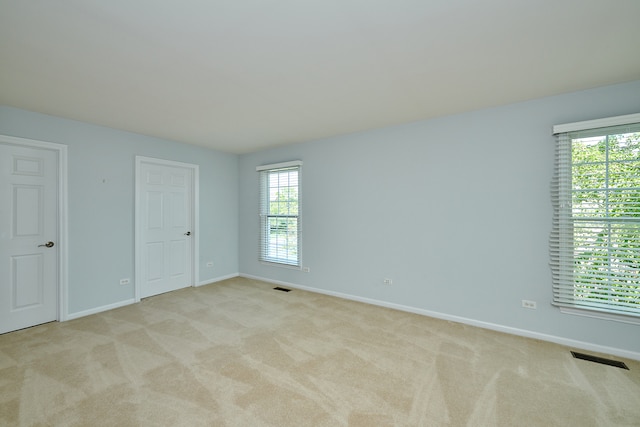 spare room featuring light carpet