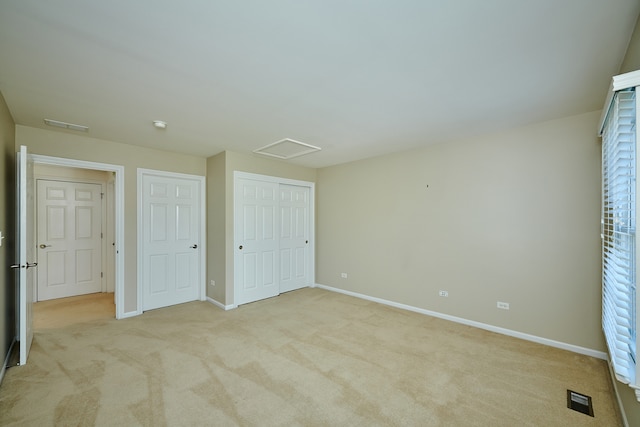 unfurnished bedroom with light carpet and a closet