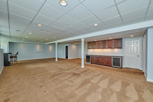 unfurnished living room featuring light carpet, indoor bar, and a drop ceiling