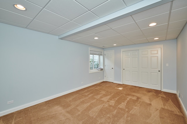 spare room featuring a paneled ceiling and carpet floors