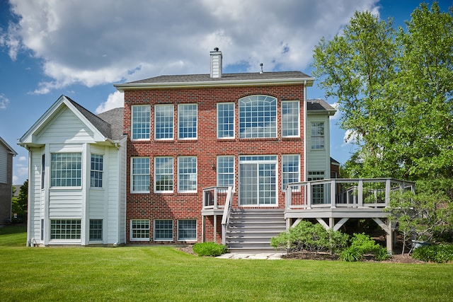 back of house featuring a lawn and a deck