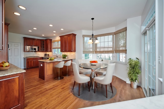 dining room featuring light hardwood / wood-style flooring, a notable chandelier, and sink