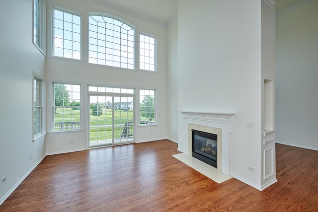 unfurnished living room with crown molding and hardwood / wood-style floors