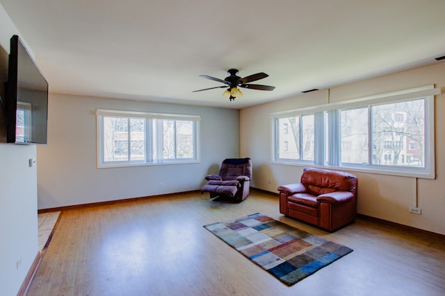 living area featuring ceiling fan and wood-type flooring