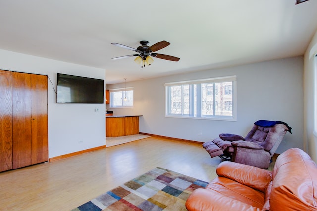 living room featuring ceiling fan and light hardwood / wood-style floors