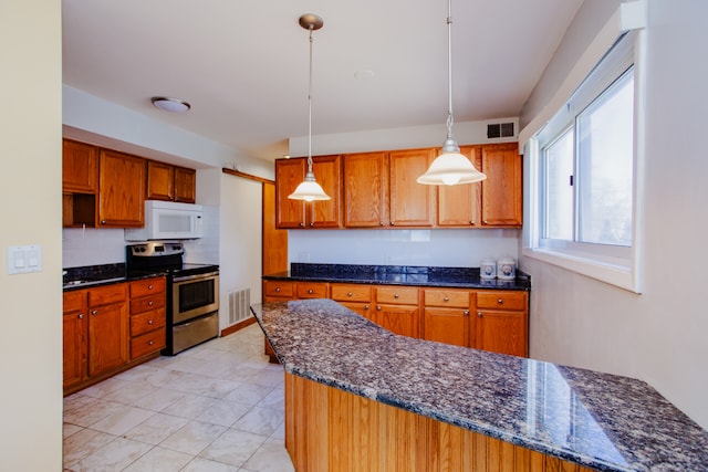 kitchen featuring hanging light fixtures, dark stone counters, stainless steel range with electric cooktop, and light tile patterned flooring