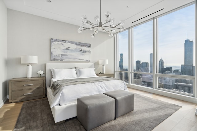 bedroom with hardwood / wood-style flooring and an inviting chandelier