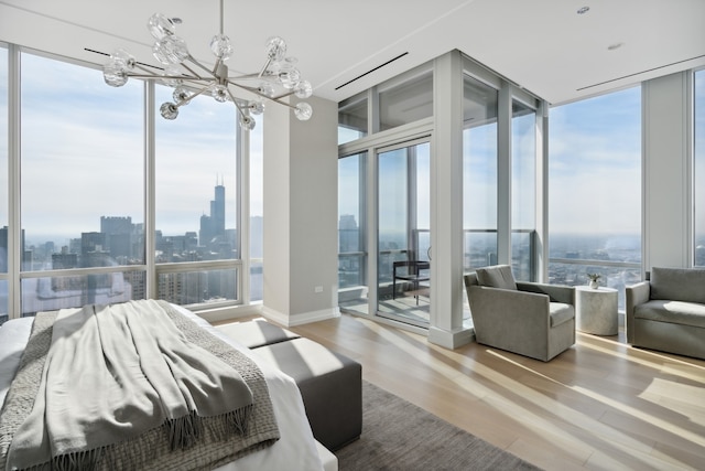 bedroom with hardwood / wood-style flooring, a notable chandelier, and multiple windows