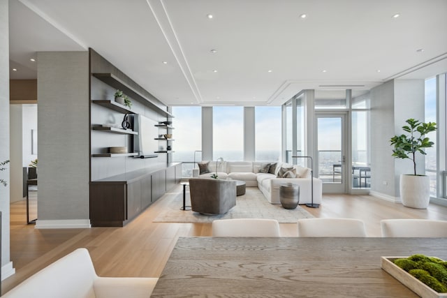 living room with a healthy amount of sunlight, light wood-type flooring, and french doors