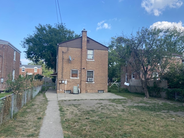 back of property with a lawn and a patio area