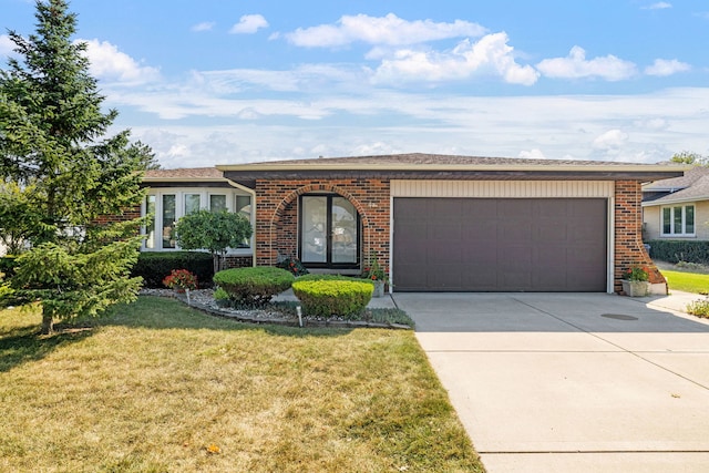 ranch-style home featuring a garage and a front lawn