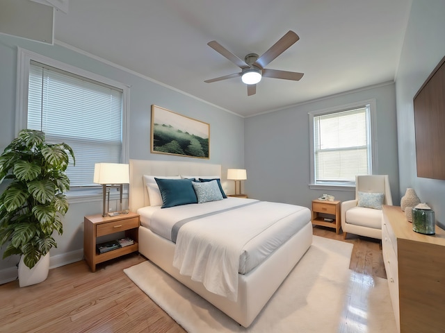 bedroom with ceiling fan, crown molding, and light hardwood / wood-style flooring