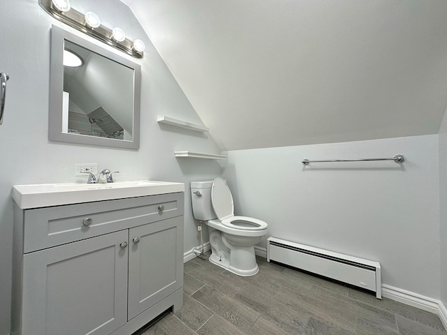 bathroom featuring toilet, hardwood / wood-style floors, vanity, baseboard heating, and vaulted ceiling