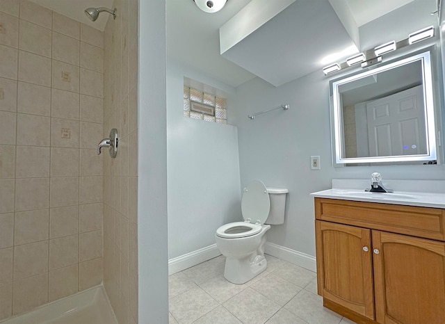 bathroom with tiled shower, tile patterned flooring, toilet, and vanity