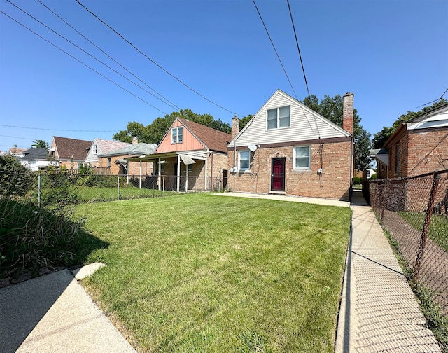 rear view of house featuring a yard