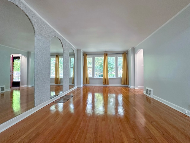 empty room with hardwood / wood-style flooring and plenty of natural light