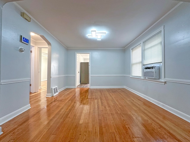 unfurnished room featuring cooling unit, light hardwood / wood-style floors, and ornamental molding