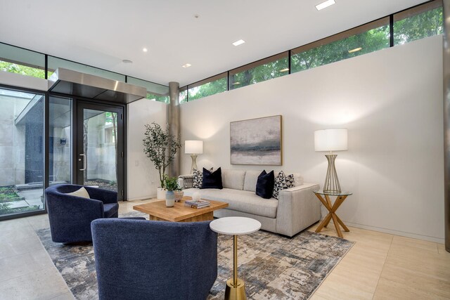 tiled living room with french doors, a healthy amount of sunlight, and expansive windows