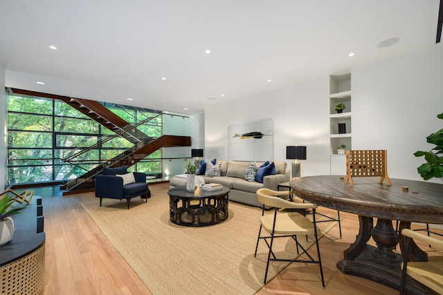 living room with built in features and light hardwood / wood-style floors