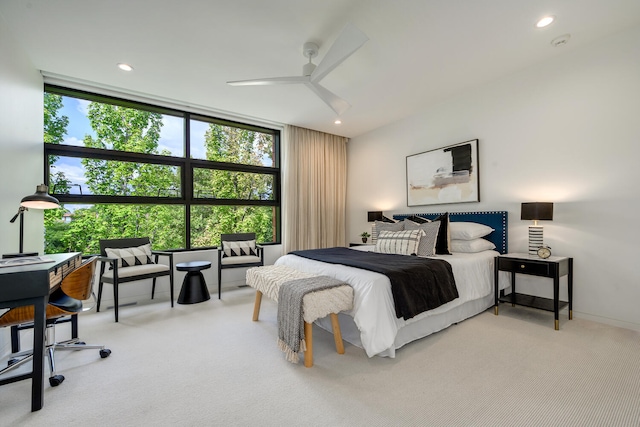 bedroom with expansive windows, ceiling fan, and light colored carpet