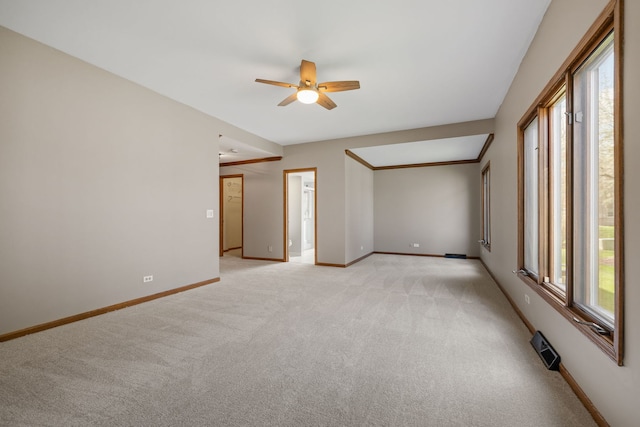 unfurnished room featuring baseboards, ceiling fan, light carpet, and visible vents