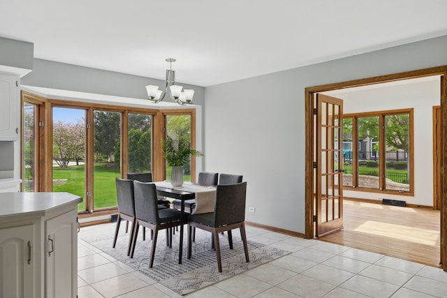 dining room featuring baseboards, an inviting chandelier, and light tile patterned floors