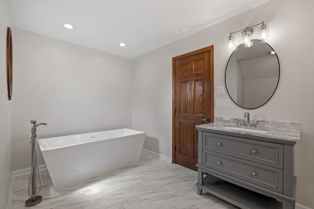 bathroom featuring vanity, marble finish floor, baseboards, recessed lighting, and a soaking tub