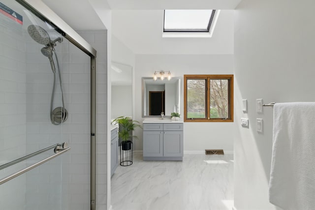 full bath with a skylight, visible vents, marble finish floor, and a stall shower