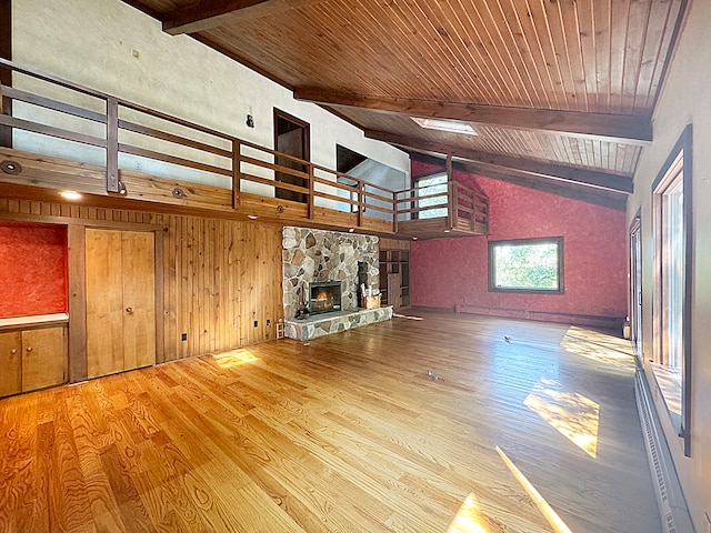 unfurnished living room featuring a fireplace, wood ceiling, wood-type flooring, and vaulted ceiling with beams