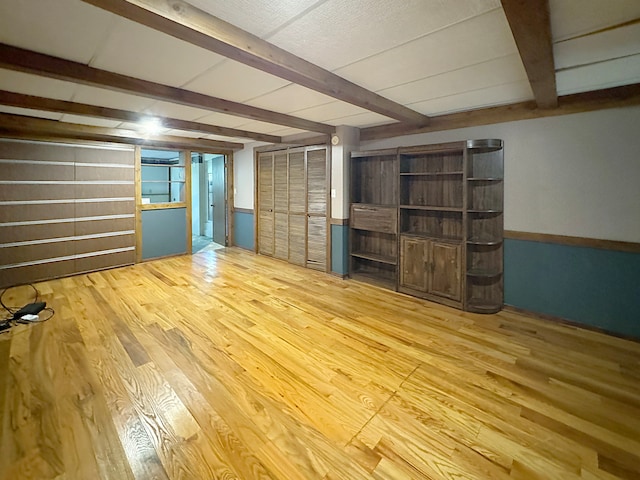 finished basement with a wainscoted wall and wood finished floors