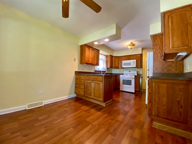 kitchen with dark wood-type flooring, white appliances, sink, and ceiling fan