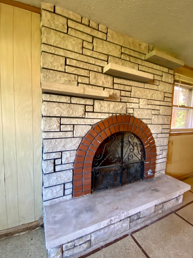 details featuring a textured ceiling and a stone fireplace